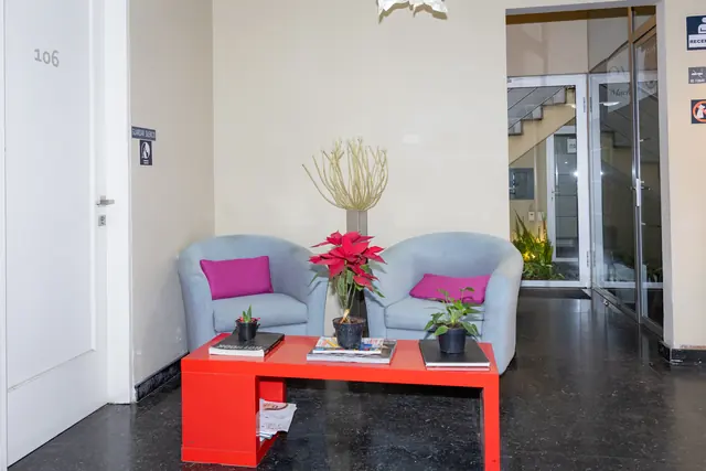 Recepción con sillones azules y mesa roja