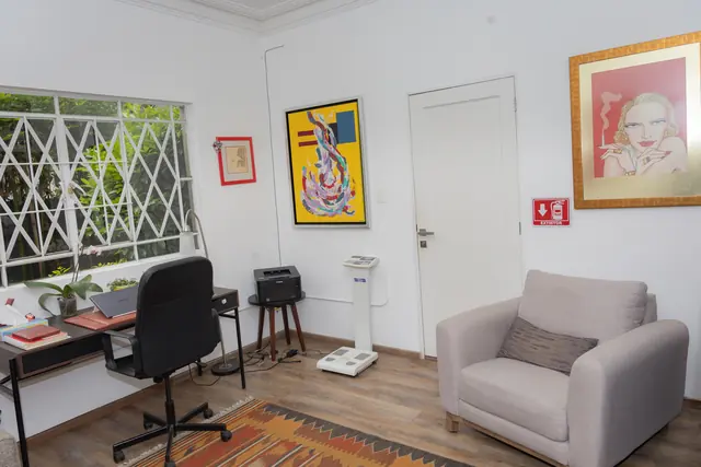 Consultorio de nutrición con escritorio, báscula y sillón