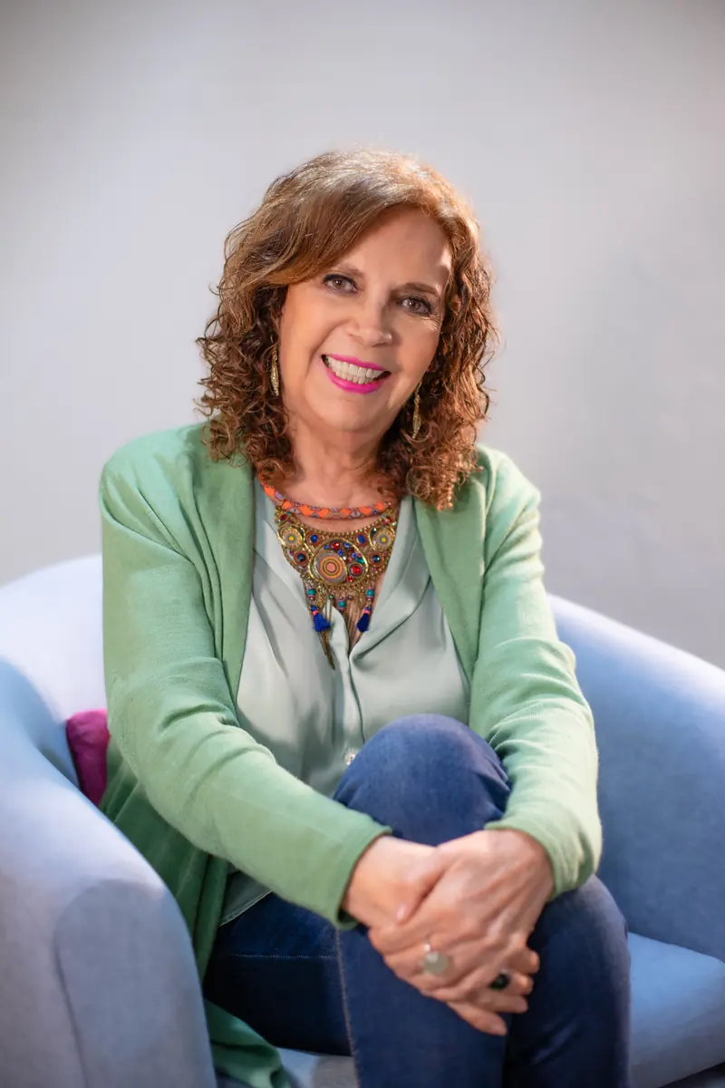 Maruza Castillo-Nájera, psicoanalista de Kairós Centro, sonriendo en un sillón azul