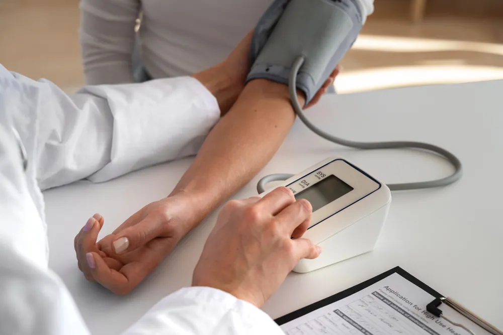 Médico midiendo la presión arterial de un paciente con un baumanómetro digital