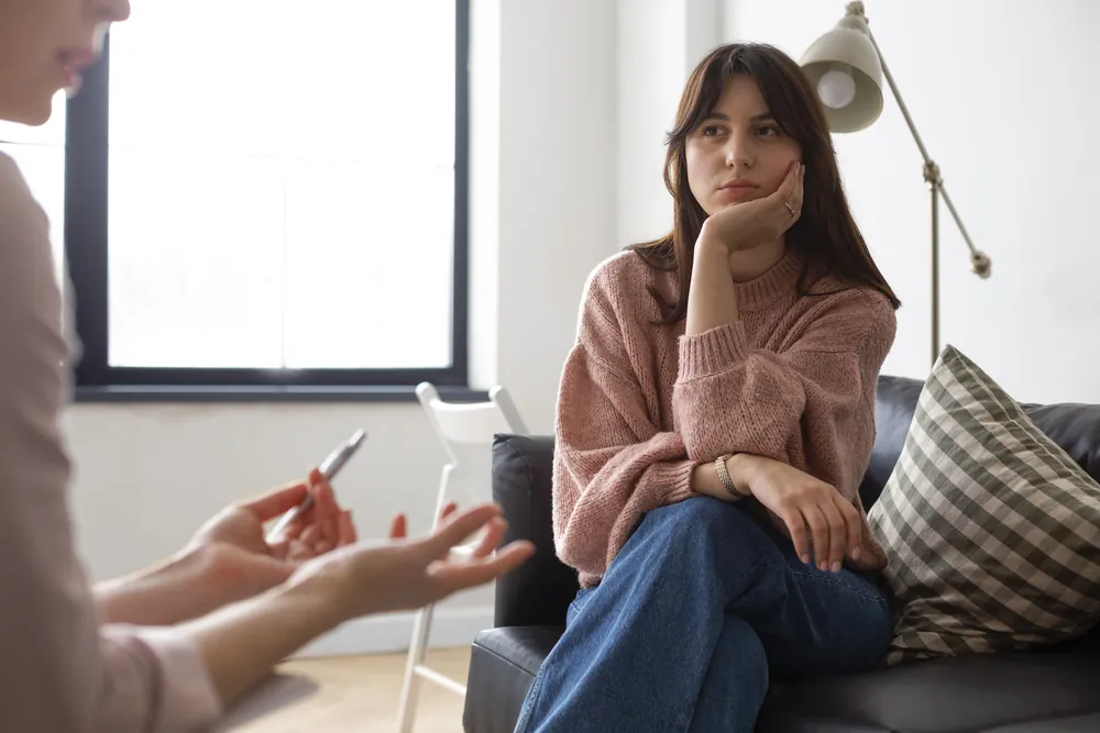 Joven conversando con su psicóloga en una sesión de terapia en el consultorio
